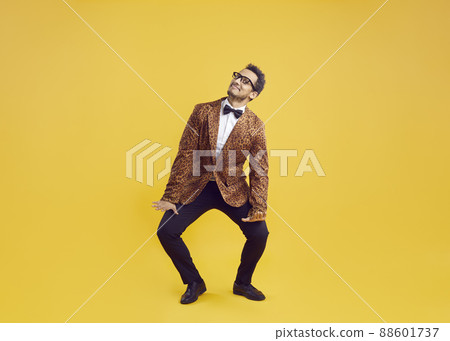 Happy funny goofy black man in leopard jacket dancing on yellow studio background Happy funny goofy black man in leopard jacket dancing on yellow studio background 88601737