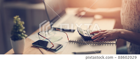 Woman working with laptop and calculator at home office 88602029
