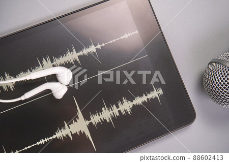 Podcast concept. Content tablet with white earphones. Close up. Audio music Podcast concept. Content tablet with white earphones. Close up. Audio music 88602413