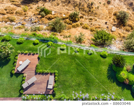 Terrace with green grass morning view. Wooden floor with chairs, looking out over the large lawn. Top view. Vacation and travel concept 88603046