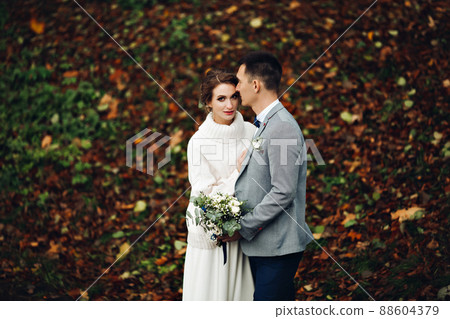 Groom and bride posing at autumn forest, among Groom and bride posing at autumn forest, among 88604379
