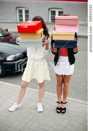 Incognito fashionable girls with piles of shoes in Incognito fashionable girls with piles of shoes in 88604382