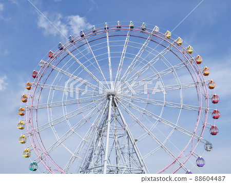 A large Ferris wheel that shines in the blue sky 88604487