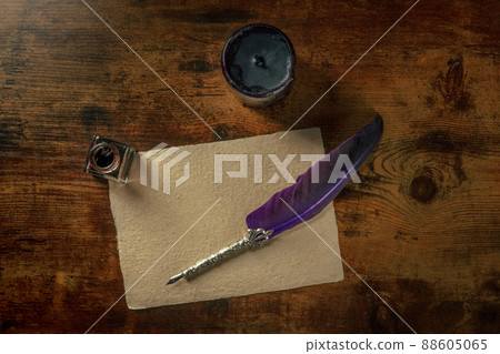 Feather quill pen with a vintage inkwell and old parchment paper Feather quill pen with a vintage inkwell and old parchment paper 88605065