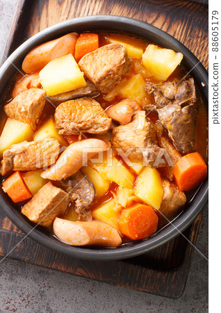 Pork Menudo is a Filipino pork stew dish with carrots and potato close up in the plate. Vertical top view Pork Menudo is a Filipino pork stew dish with carrots and potato close up in the plate. Vertical top view 88605179