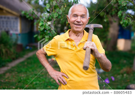 Senior man standing in yard of his country house Senior man standing in yard of his country house 88605483