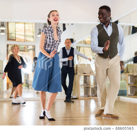 Woman with african man practising charleston dancing 88605563