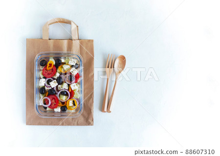 Glass container with greek salad, wooden cutlery, paper bag, zero waste Glass container with greek salad, wooden cutlery, paper bag, zero waste 88607310