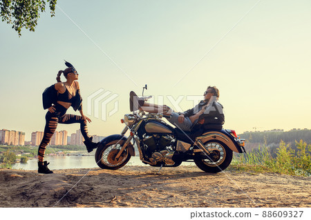 Sexy couple of bikers on the vintage custom motorcycle, girl in a rabbit mask Sexy couple of bikers on the vintage custom motorcycle, girl in a rabbit mask 88609327