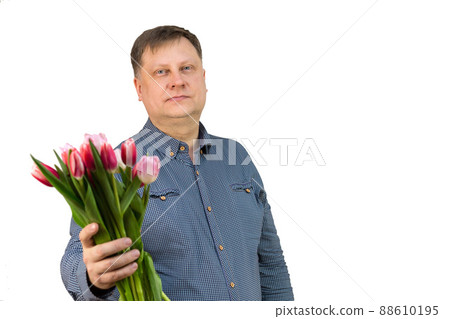 Sexy adult man in a blue shirt with a bouquet of fragrant tulips on a white background Sexy adult man in a blue shirt with a bouquet of fragrant tulips on a white background 88610195
