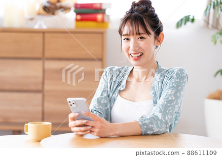 一個操作智能手機的年輕女子 88611109