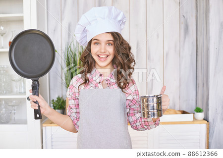 Young girl cooking kitchen. Curly pretty child portrait. Chef christmas student 88612366