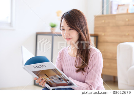 A woman reading a book in the living room A woman reading a book in the living room 88612679