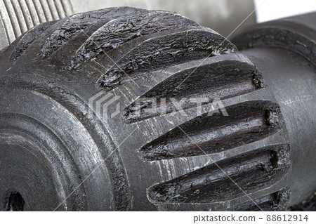 dumbbell with gear part of an industrial machine made of iron lubricated with grease for rubbing parts, a close-up of the object of an automobile structure. dumbbell with gear part of an industrial machine made of iron lubricated with grease for rubbing parts, a close-up of the object of an automobile structure. 88612914
