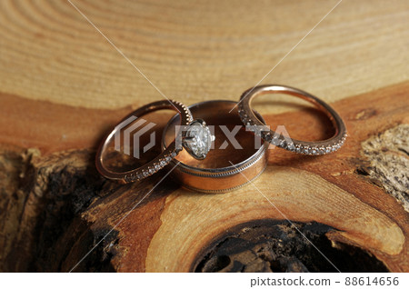 White Gold and Diamond Wedding and Engagement Rings Arranged on Rustic Wood Tree Slice White Gold and Diamond Wedding and Engagement Rings Arranged on Rustic Wood Tree Slice 88614656