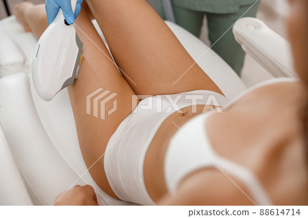 Closeup of female client getting epilation with ipl machine in beauty salon 88614714