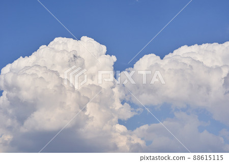 Big white fluffy cumulonimbus clouds floating on blue sky on bright sunny day. 88615115