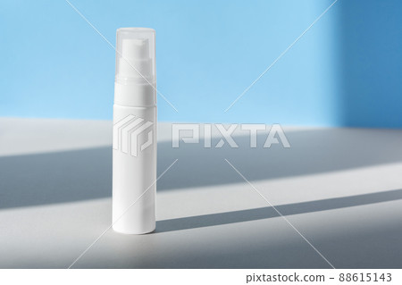 Cream dispenser template front view on blue surface with shadow from windows. Facial lotion, moisturizer, skin care beauty cosmetic bottle mockup. Brand spa product packaging mock up. 88615143