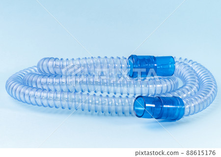 Tubing for CPAP or BIPAP machine isolated on blue background. Medical equipment 88615176