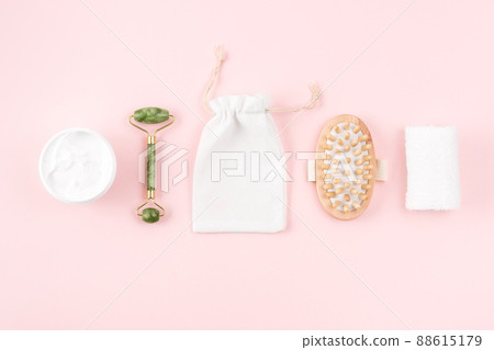 Spa set, towels, massaging brush, body cream, marble roller on pink surface. Eco zero waste concept. Spa set, towels, massaging brush, body cream, marble roller on pink surface. Eco zero waste concept. 88615179