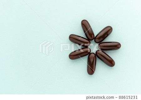 Brown gelatinous capsules, vitamin b, supplementary food on blue background. 88615231