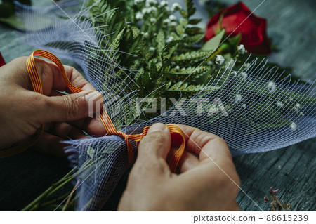 man arranges a red rose for Saint George Day 88615239