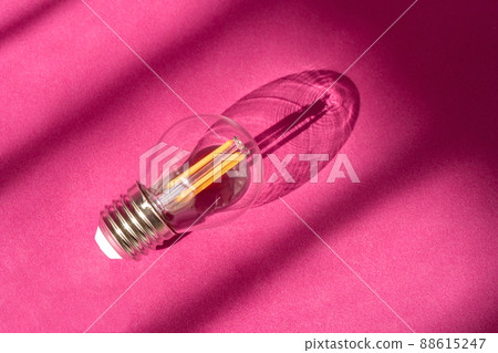 Light bulb on purple background with shadows close up. Lightbulb on surface. Selective focus. Creative new idea, innovation, inspiration concept Light bulb on purple background with shadows close up. Lightbulb on surface. Selective focus. Creative new idea, innovation, inspiration concept 88615247