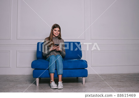 Cheerful woman with smartphone in modern room Cheerful woman with smartphone in modern room 88615469