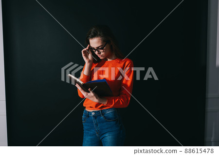 Focused female immersing in reading interesting book 88615478