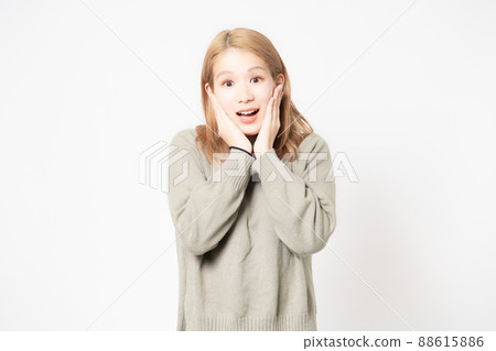Surprised young woman standing in front of white background 88615886