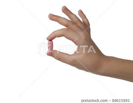 Demonstration of a pill between the fingers of the hand. Demonstration of a pill between the fingers of the hand. 88615891