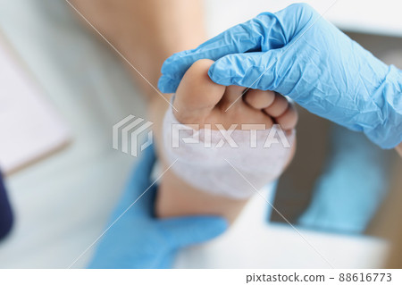 Doctor conducts medical examination of foot with patch 88616773