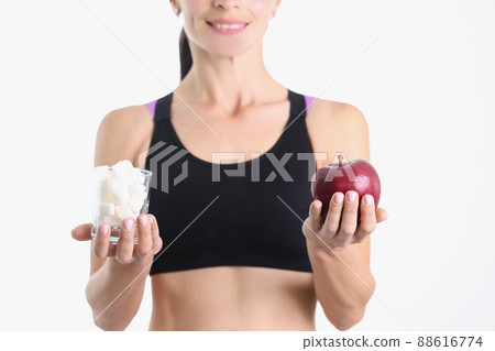 Woman is holding glass of sugar and ripe apple closeup 88616774