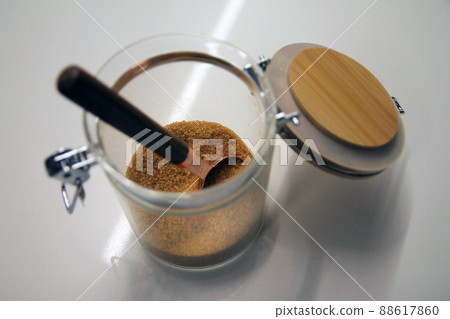 Close up of a isolated glass and wood cane sugar jar with a copper and wood spoon 88617860