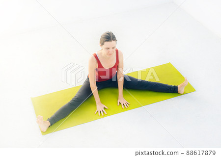 Side view portrait of beautiful young woman doing yoga or pilates exercise on white background Side view portrait of beautiful young woman doing yoga or pilates exercise on white background 88617879