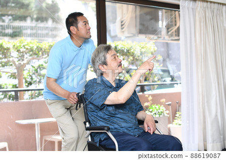 Wheelchair-riding elderly and male caregivers 88619087