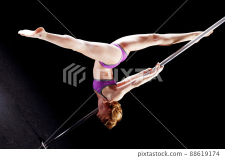 The strong and graceful young girl performing acrobatic exercises on pylon The strong and graceful young girl performing acrobatic exercises on pylon 88619174