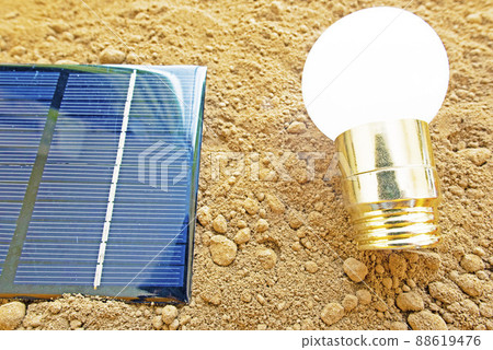 Light bulbs and solar panels placed on the soil 88619476