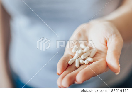 Womans hand is holding pills. Overdose of medicinal capsules in palms close-up. World Health Day. 88619513