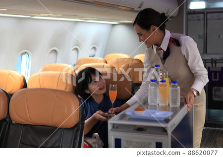 Cabin crew pushing service cart and serve to customer on the airplane during flight. hostess service on plane 88620077