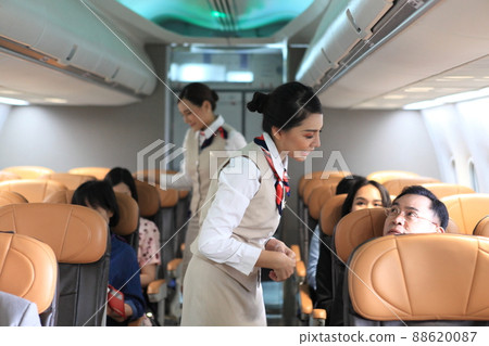 air  hostess service on plane , flight attendant checking and closing cabin compartment in airplane 88620087