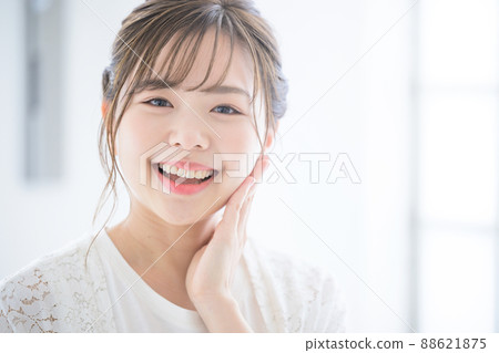 A woman looking at the camera with a smile up. There is a copy space on the right side of the front. 88621875