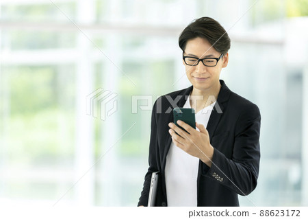 一個三十多歲的男人用智能手機的休閒商業形象 88623172