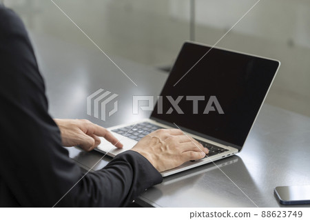 At hand of a businessman working on a laptop At hand of a businessman working on a laptop 88623749
