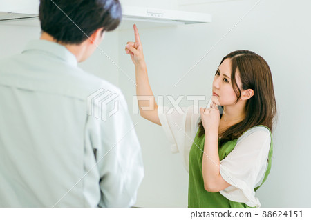 Men and women in work clothes talking in the kitchen (ventilation fan / complaint) 88624151