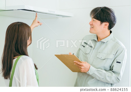 Men and women in work clothes talking in the kitchen (ventilation fan) Men and women in work clothes talking in the kitchen (ventilation fan) 88624155