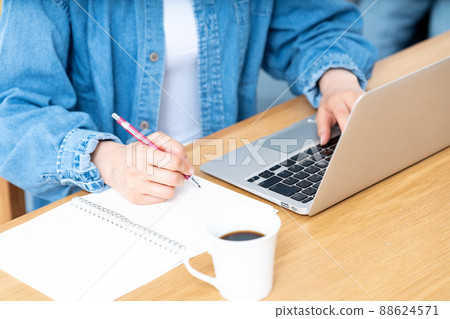 一邊做筆記一邊用筆記本電腦的女人的手[零件切割] 88624571