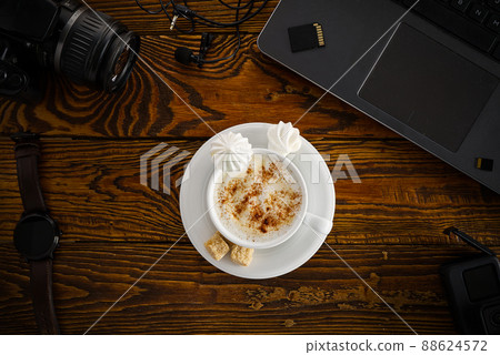 Work from home. desk office with laptop and camera, coffee cup on wood table. Flat lay top view 88624572