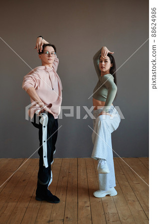 Two youthful vogue dancers in activewear keeping their legs bent in knee 88624986