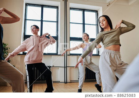 Group of contemporary active teens practicing vogue dancing movements 88625083